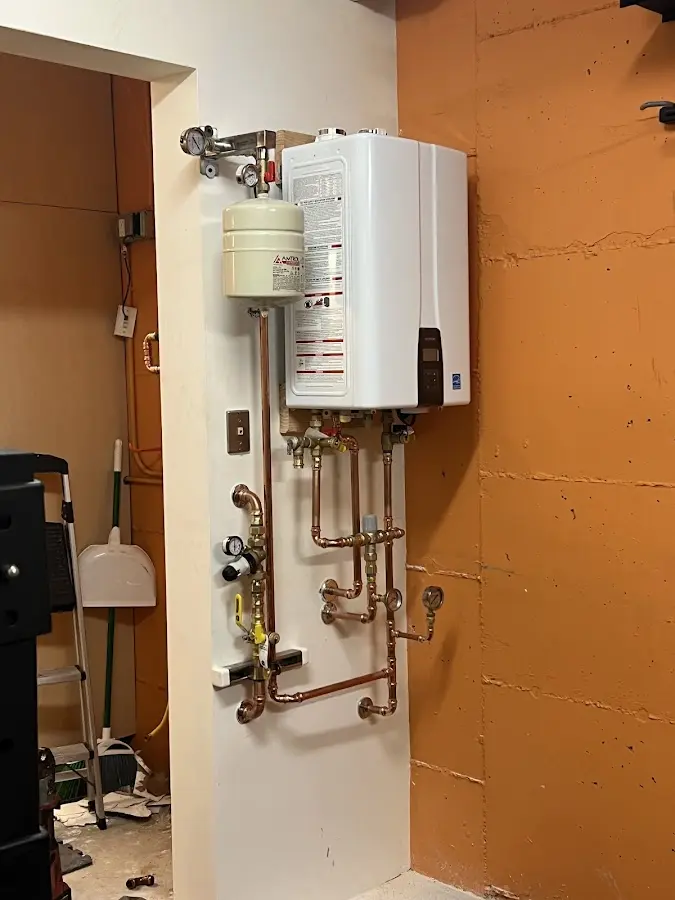 Plumbing technician inspecting water heater connections in Seguin